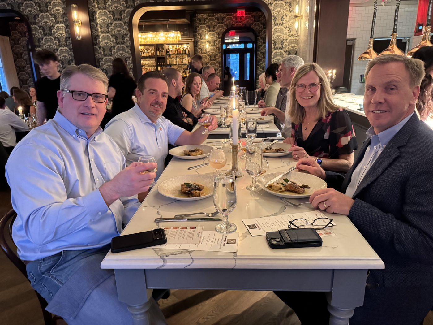 Guests connecting and enjoying whiskey at a Grotto Whiskey Club dinner